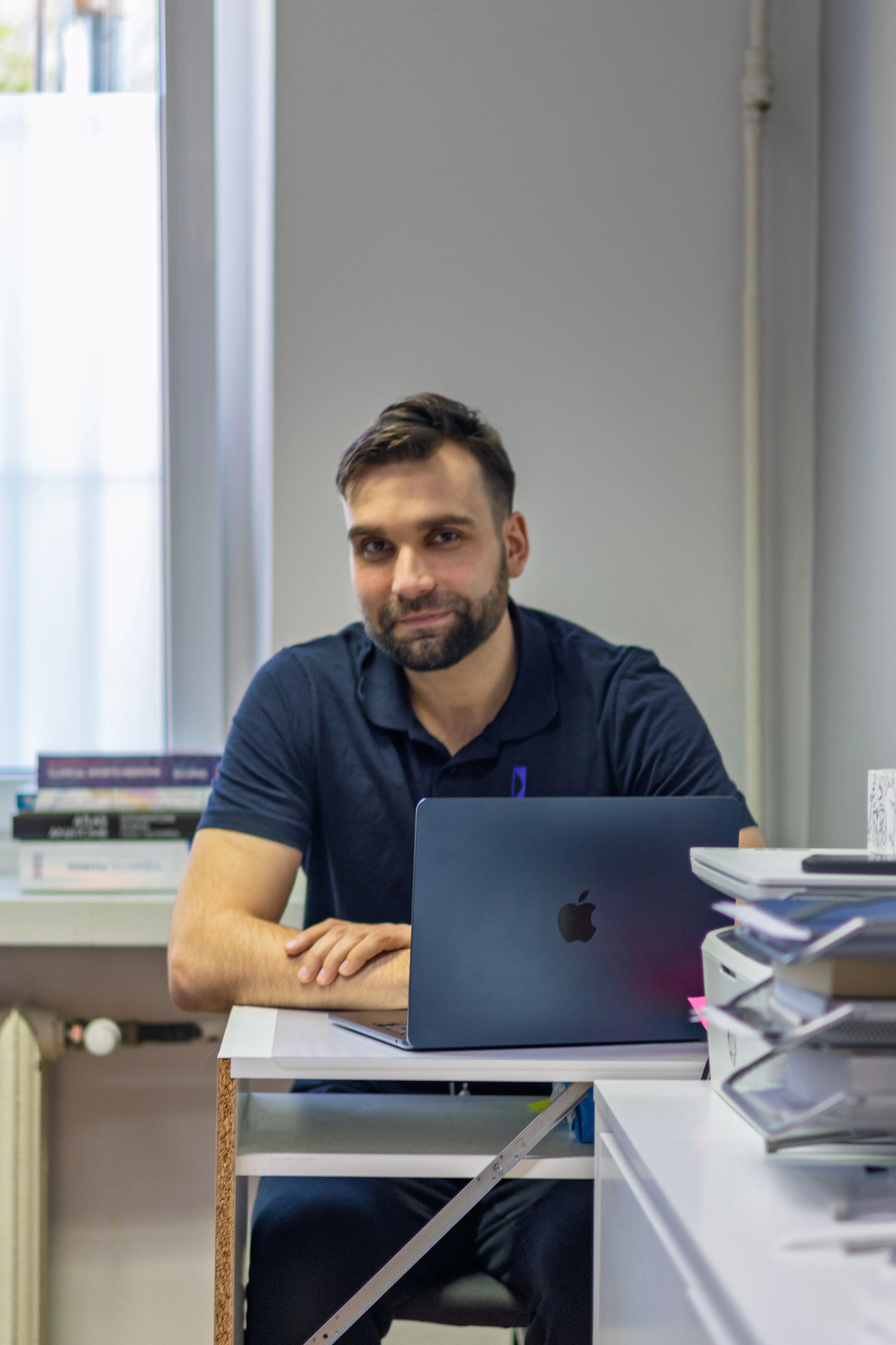 Łukasz Bielecki – fizjoterapeuta przy biurku z laptopem